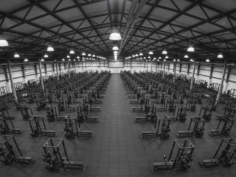 Il proprietario di una palestra guarda un cronometro mentre tiene in mano uno strumento di riparazione